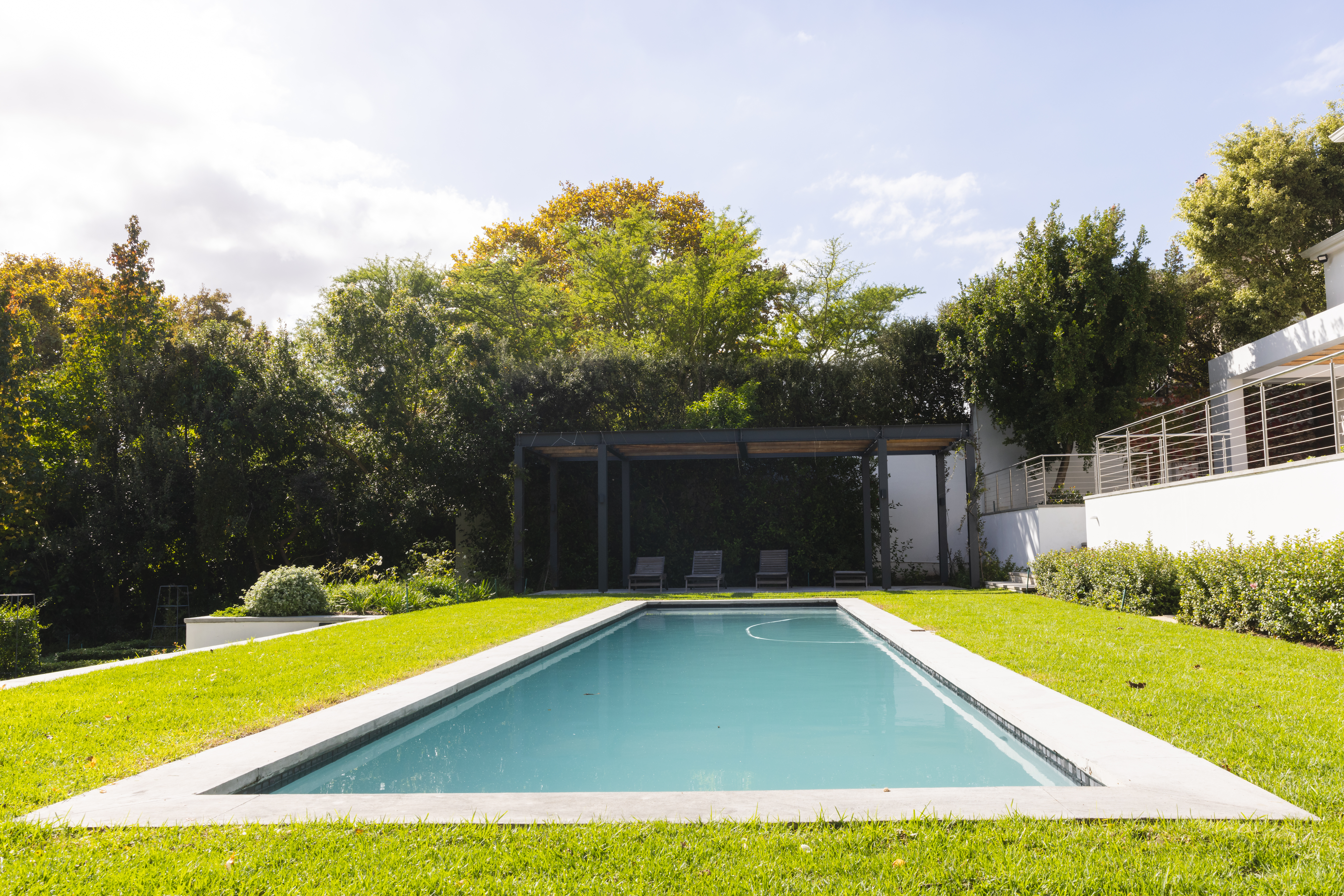 General view of big pool in home garden of modern house on sunny day. Nature, garden design, luxury and architecture.