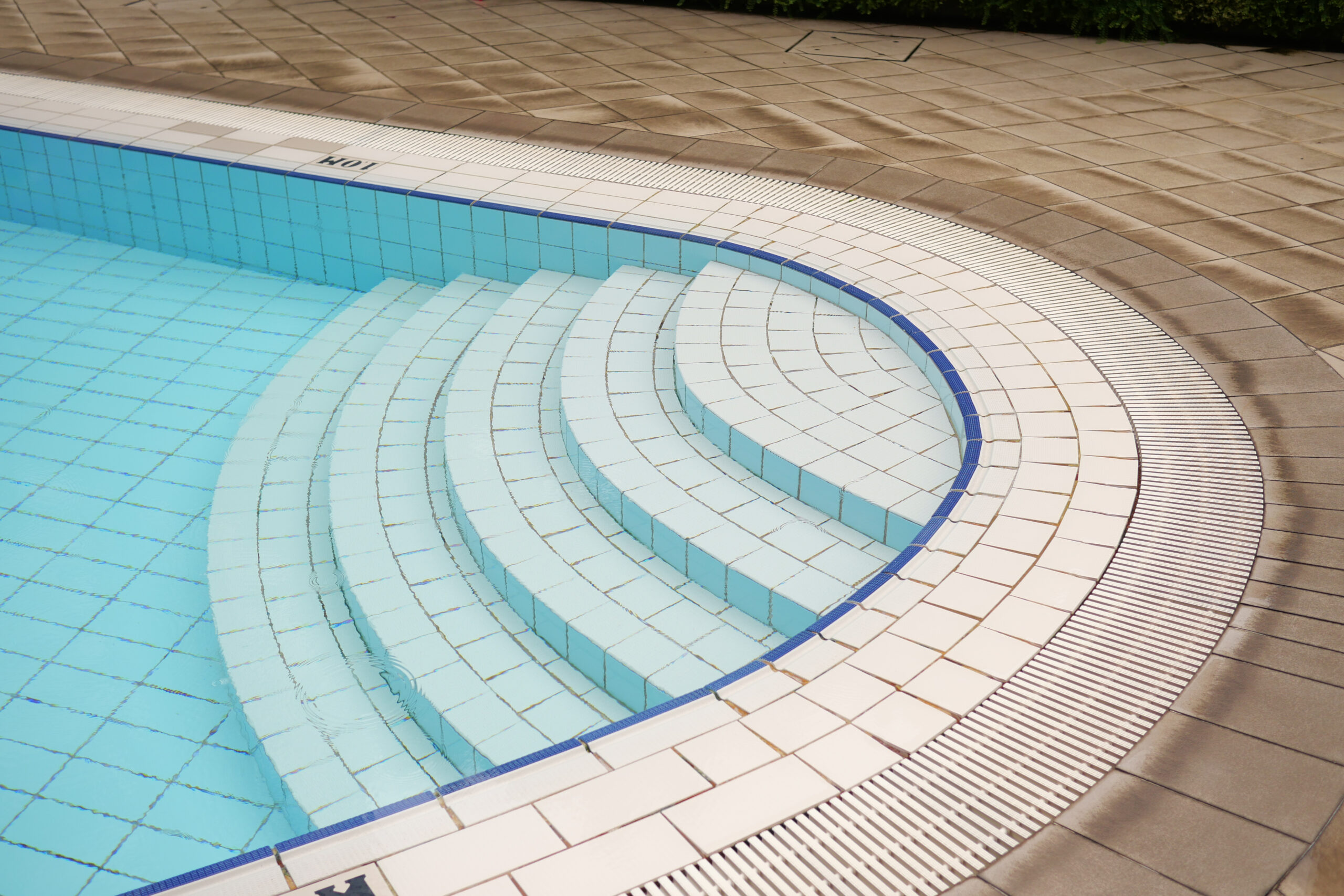 an empty swimming pool with poll stair.