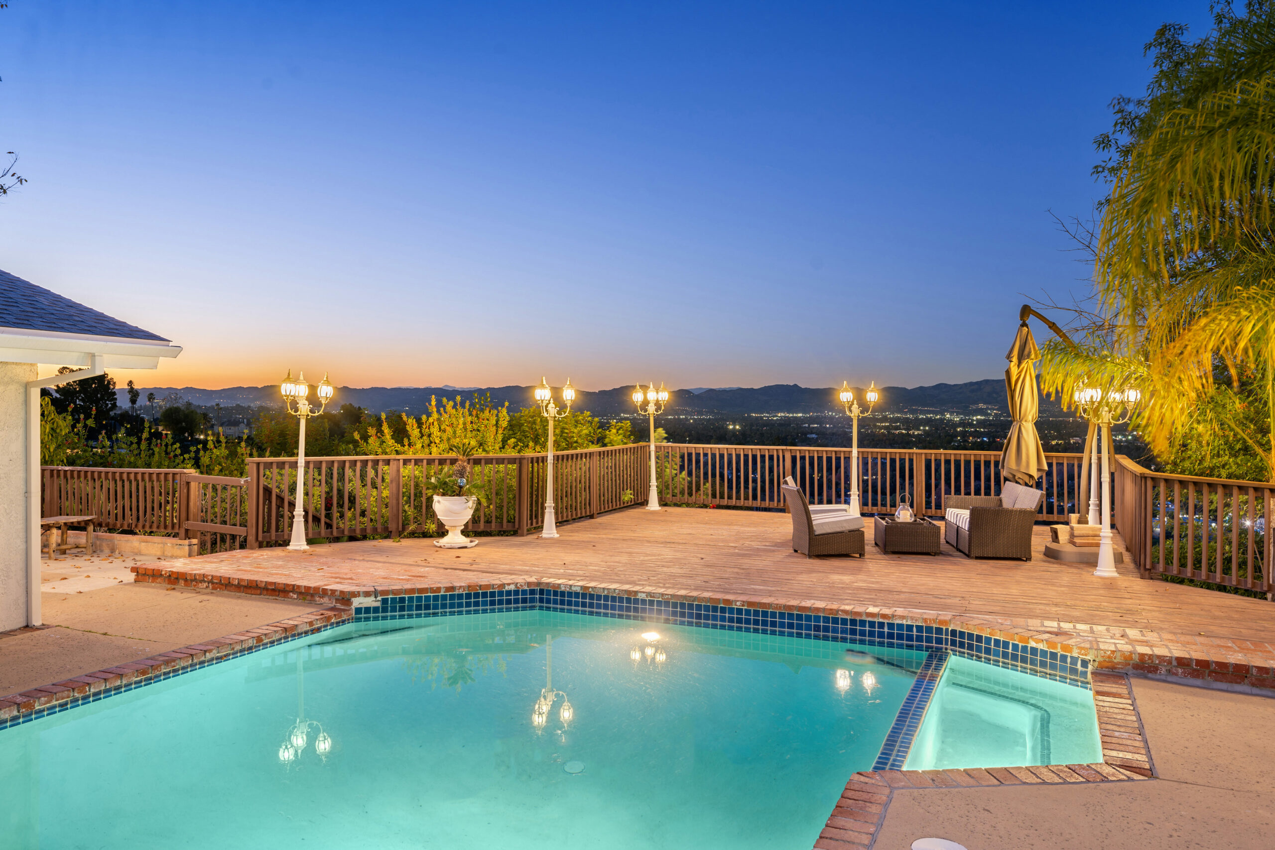 An illuminated pool alongside a house at night in Encino, California