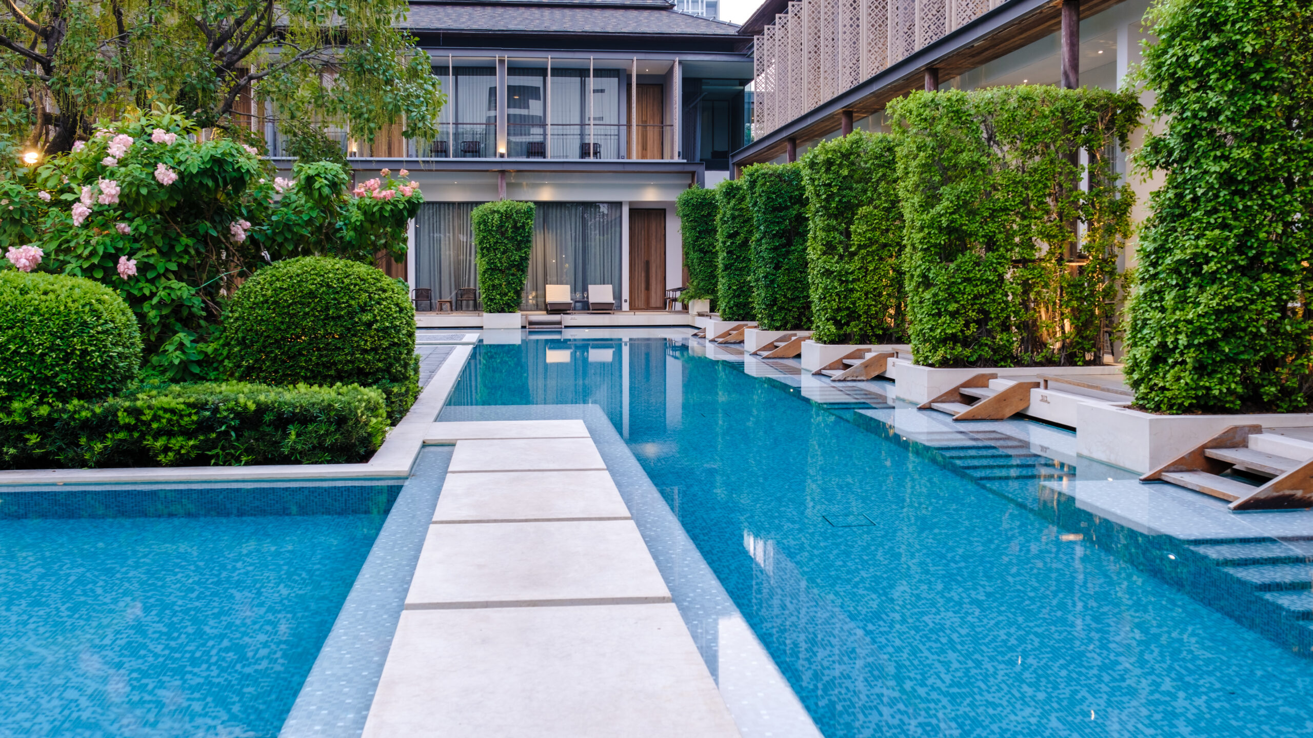 Luxury 5 star hotel pool in Asia with chairs.