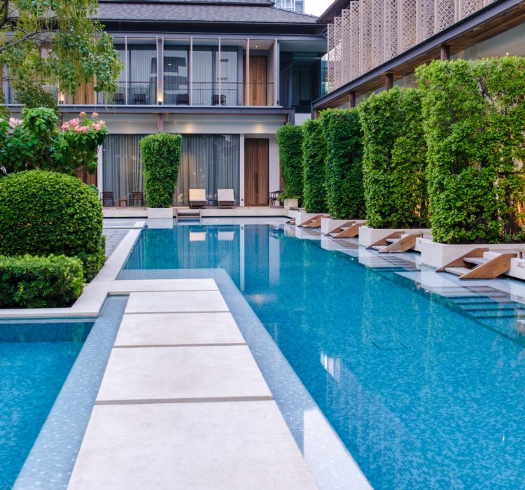 Luxury 5 star hotel pool in Asia with chairs.